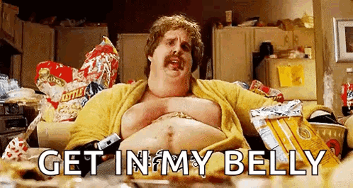 A Fat Man With A Mustache Is Sitting On A Couch In A Messy Kitchen . GIF