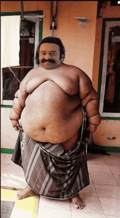 A Fat Man With A Mustache Is Standing In Front Of A Building GIF