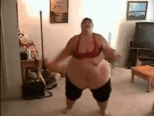 A Fat Woman Is Dancing In A Living Room With A Television In The Background . GIF
