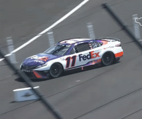 A Fedex Race Car Is Driving Down The Track GIF