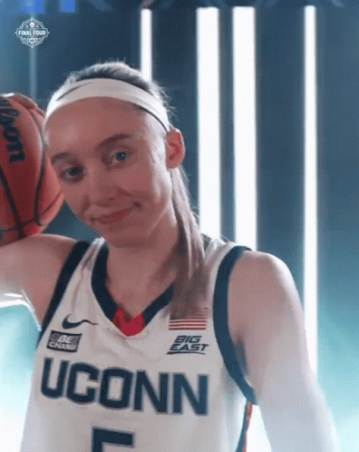 A Female Basketball Player From Uconn Holds A Wilson Basketball Over Her Head GIF