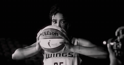 A Female Basketball Player Is Holding A Basketball In Front Of Her Face In A Black And White Photo . GIF