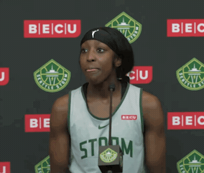 A Female Basketball Player Stands In Front Of A Microphone Wearing A Storm Jersey GIF