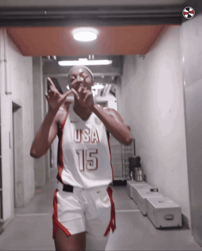 A Female Basketball Player Wearing A Usa 15 Jersey Is Giving A Peace Sign GIF