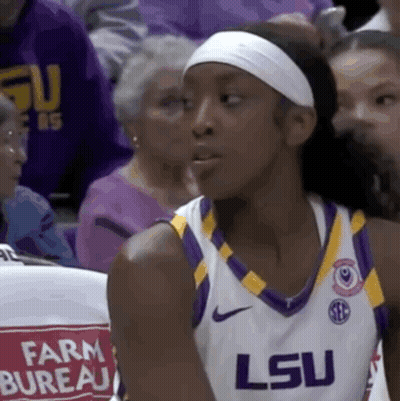 A Female Basketball Player Wearing A White Headband And A Lsu Jersey . GIF