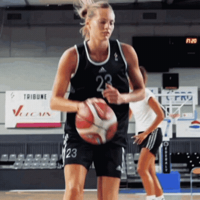 A Female Basketball Player Wearing Number 23 Is Dribbling A Ball GIF