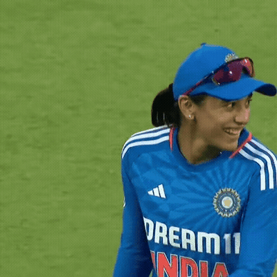 A Female Cricket Player Wearing A Blue Hat And Sunglasses Is Smiling . GIF