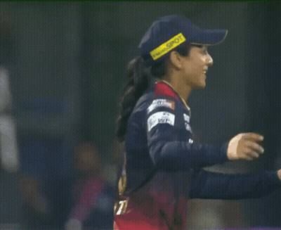 A Female Cricket Player Wearing A Blue Hat With A Yellow Stripe That Says ' Sdn ' On It GIF