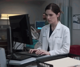 A Female Doctor In A Lab Coat Is Typing On A Keyboard GIF