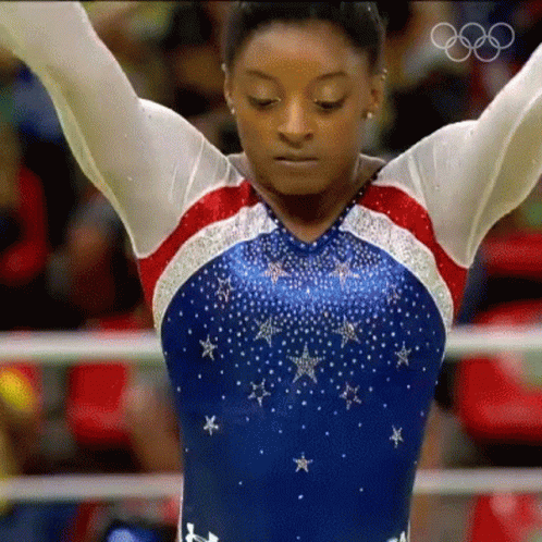 A Female Gymnast In A Red White And Blue Leotard With Stars On It GIF