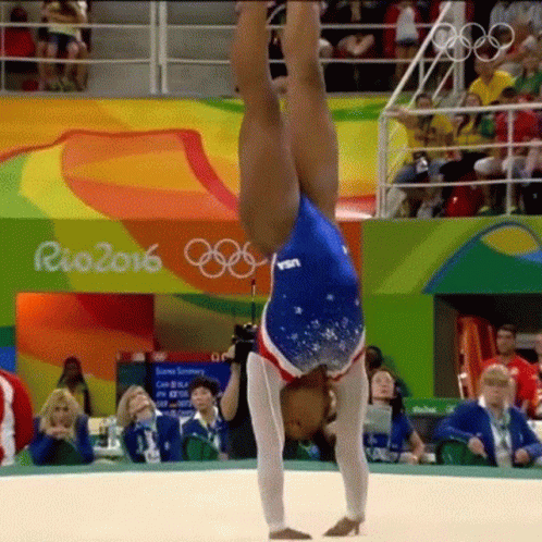 A Female Gymnast Is Doing A Handstand In Front Of A Crowd At Rio 2016 GIF