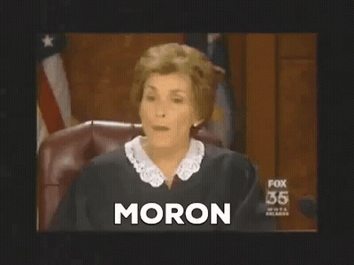 A Female Judge Is Sitting In A Courtroom And The Word Moron Is On The Screen . GIF