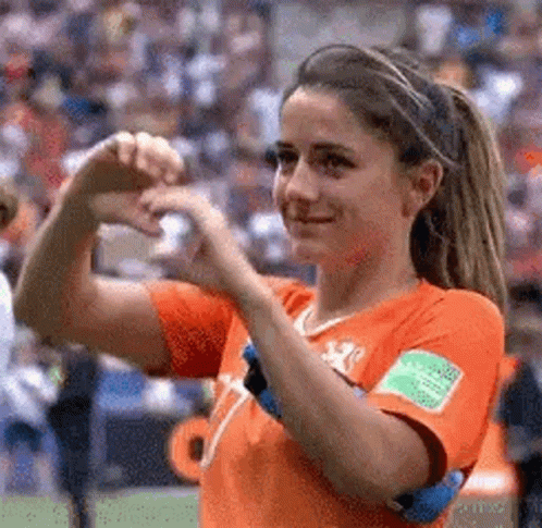 A Female Soccer Player Is Making A Heart Shape With Her Hands On A Field . GIF
