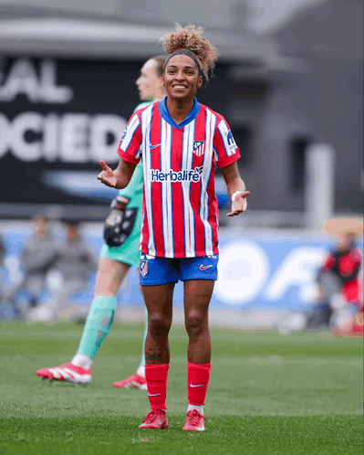 A Female Soccer Player Wearing A Red And White Striped Shirt With The Word Herbalife On It GIF