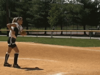A Female Softball Player Throws A Ball While Standing On A Field GIF