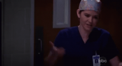 A Female Surgeon Wearing A Scrub Top And A Name Tag With Abc On It GIF