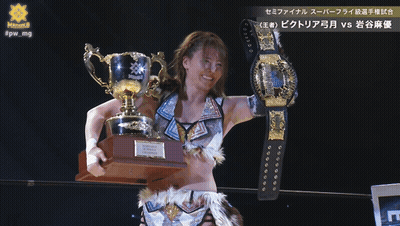A Female Wrestler Holding A Trophy And A Belt That Says Victoria GIF