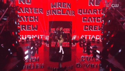 A Female Wrestler Named Wren Sinclair Is Standing In Front Of A Red Wall GIF