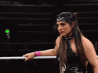 A Female Wrestler Wearing A Headband And A Pink Wristband GIF