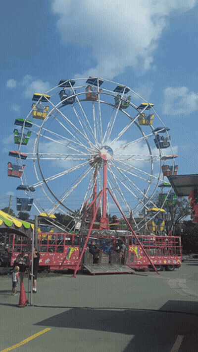 A Ferris Wheel At A Carnival With People Riding It GIF