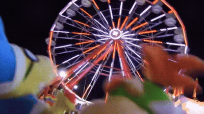 A Ferris Wheel At An Amusement Park At Night With A Circle In The Middle GIF