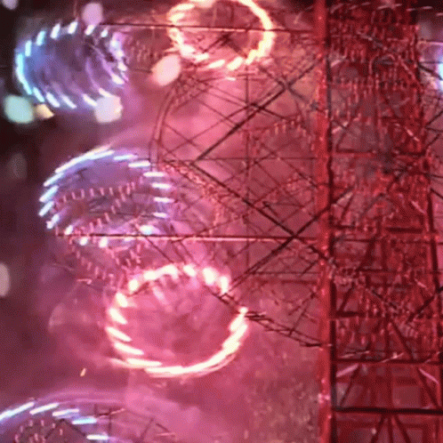 A Ferris Wheel Is Lit Up At Night With A Red Background GIF