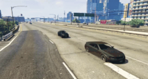 A Few Cars Are Driving Down A Highway With A City In The Background GIF