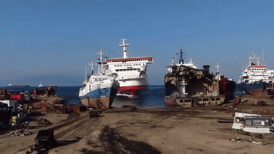 A Few Ships Are Sitting On A Beach And One Of Them Says ' Norwegian ' On The Side GIF