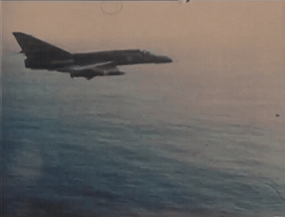 A Fighter Jet Is Flying Over A Body Of Water With The Number 21 On The Side GIF