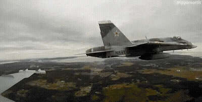 A Fighter Jet Is Flying Over A Landscape With A Large Star On The Tail . GIF