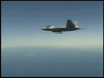 A Fighter Jet Is Flying Through The Air With A Missile Attached To It GIF