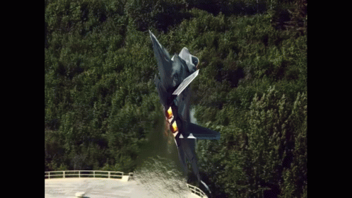 A Fighter Jet Is Taking Off From A Runway In The Woods GIF
