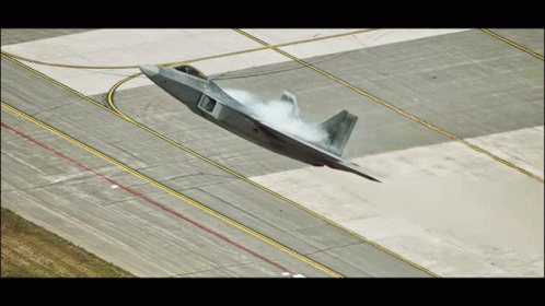 A Fighter Jet Is Taking Off From A Runway With Smoke Coming Out Of The Nose GIF