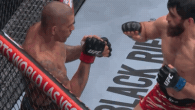 A Fighter Wearing Ufc Gloves Throws A Punch Against Another Fighter GIF