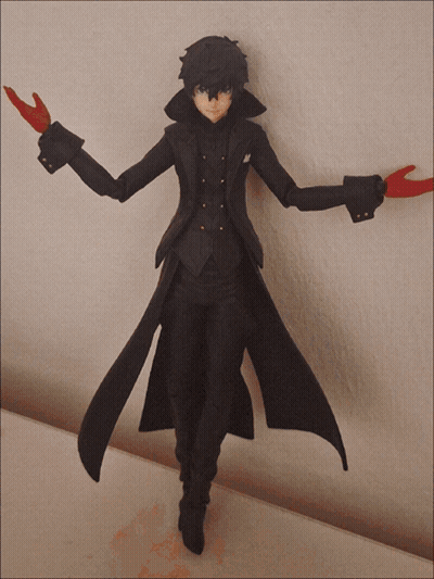 A Figurine Of A Man In A Black Coat With Red Gloves Is Standing On A Table GIF