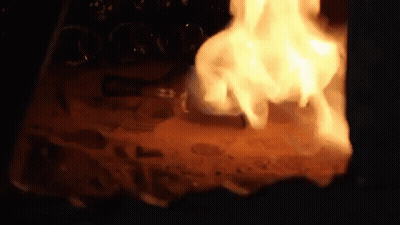 A Fire Is Burning In A Dark Room With A Lot Of Smoke Coming Out Of It GIF