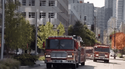 A Fire Truck With The Letter L On The Front Is Driving Down The Street GIF