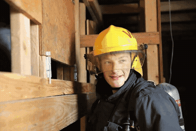 A Firefighter Wearing A Yellow Helmet With The Letter N On It GIF