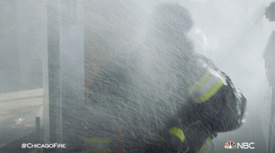 A Fireman Is Spraying Water From A Hose With The Hashtag #Chicagofire On The Bottom GIF