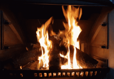 A Fireplace With A Lot Of Logs Burning And A Few Letters On The Bottom GIF