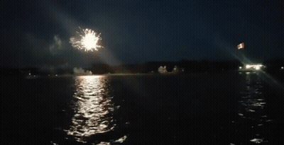 A Firework Display Over A Body Of Water GIF