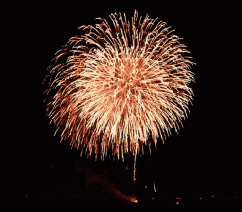 A Fireworks Display In The Night Sky With A Large Firework In The Middle GIF