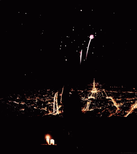 A Fireworks Display Over A City At Night With The Eiffel Tower In The Background GIF