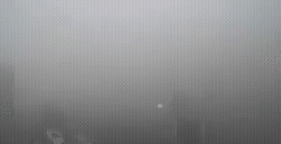 A Foggy City Skyline With A Lot Of Smoke Coming Out Of A Window . GIF