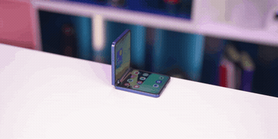 A Folding Phone Is Sitting On A White Table GIF