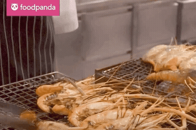 A Foodpanda Logo Can Be Seen Behind A Grilled Shrimp GIF