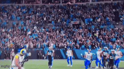 A Football Game Is Being Played In A Stadium With A Large Crowd Watching . GIF