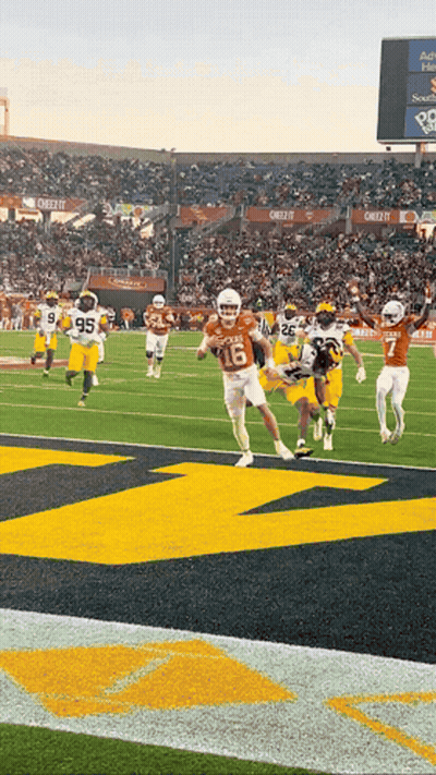 A Football Game Is Being Played In A Stadium With A Large M On The Field GIF