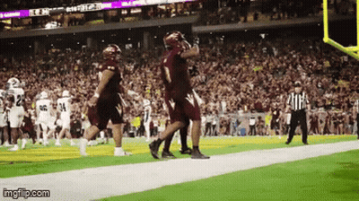 A Football Game Is Being Played In A Stadium With A Referee Watching GIF