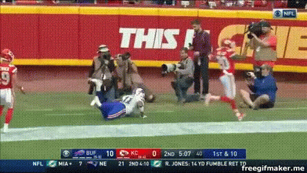 A Football Game Is Being Played In Front Of A Sign That Says This ! GIF